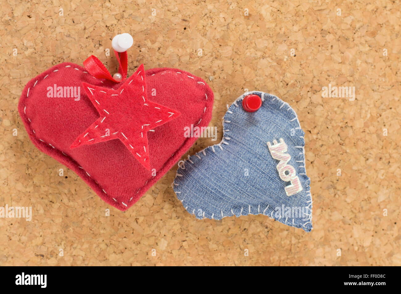 Cuore rosso e denim cuore appeso contro uno sfondo di legno Foto Stock