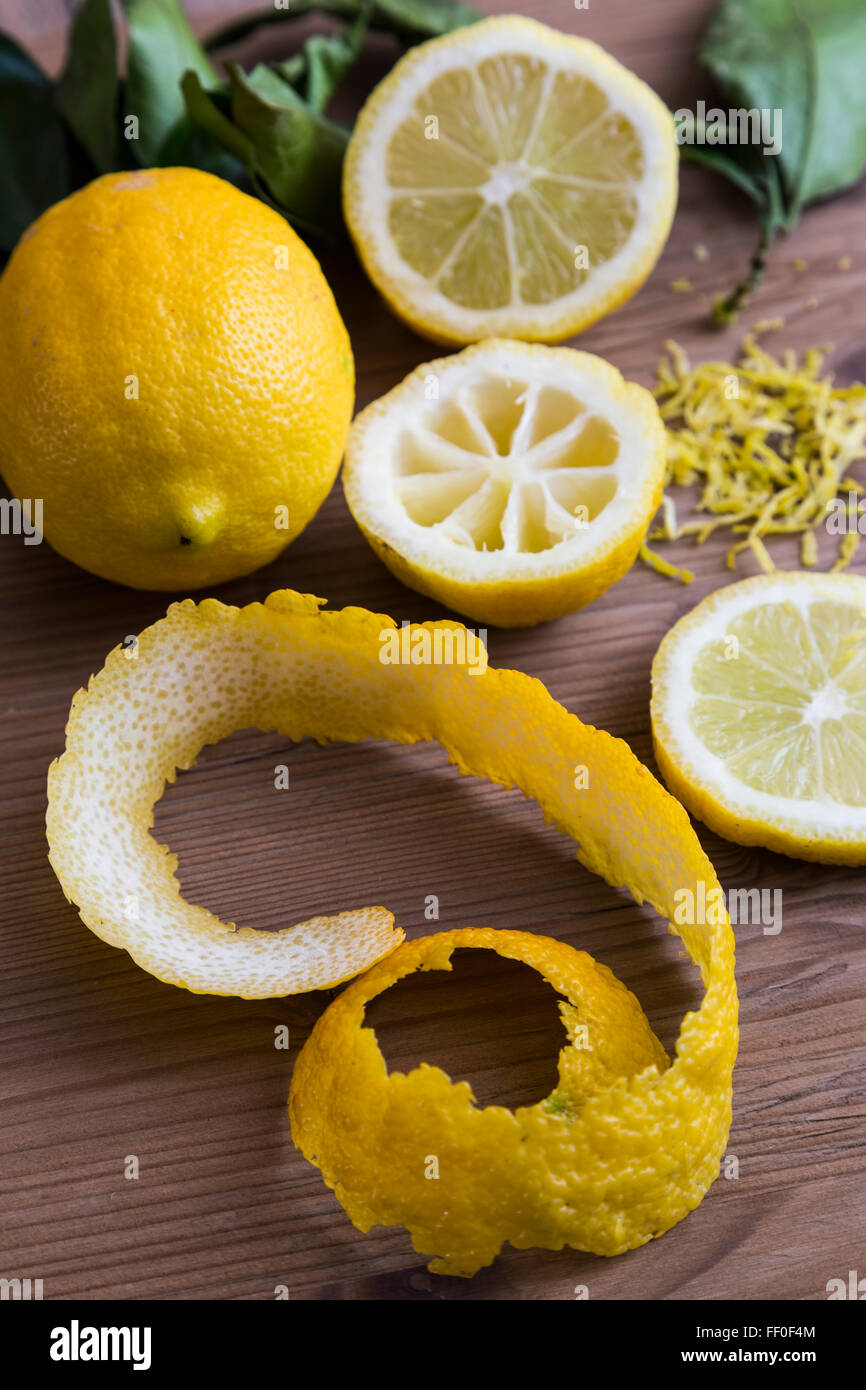 Fette di limone con buccia grattugiata e foglie Foto Stock