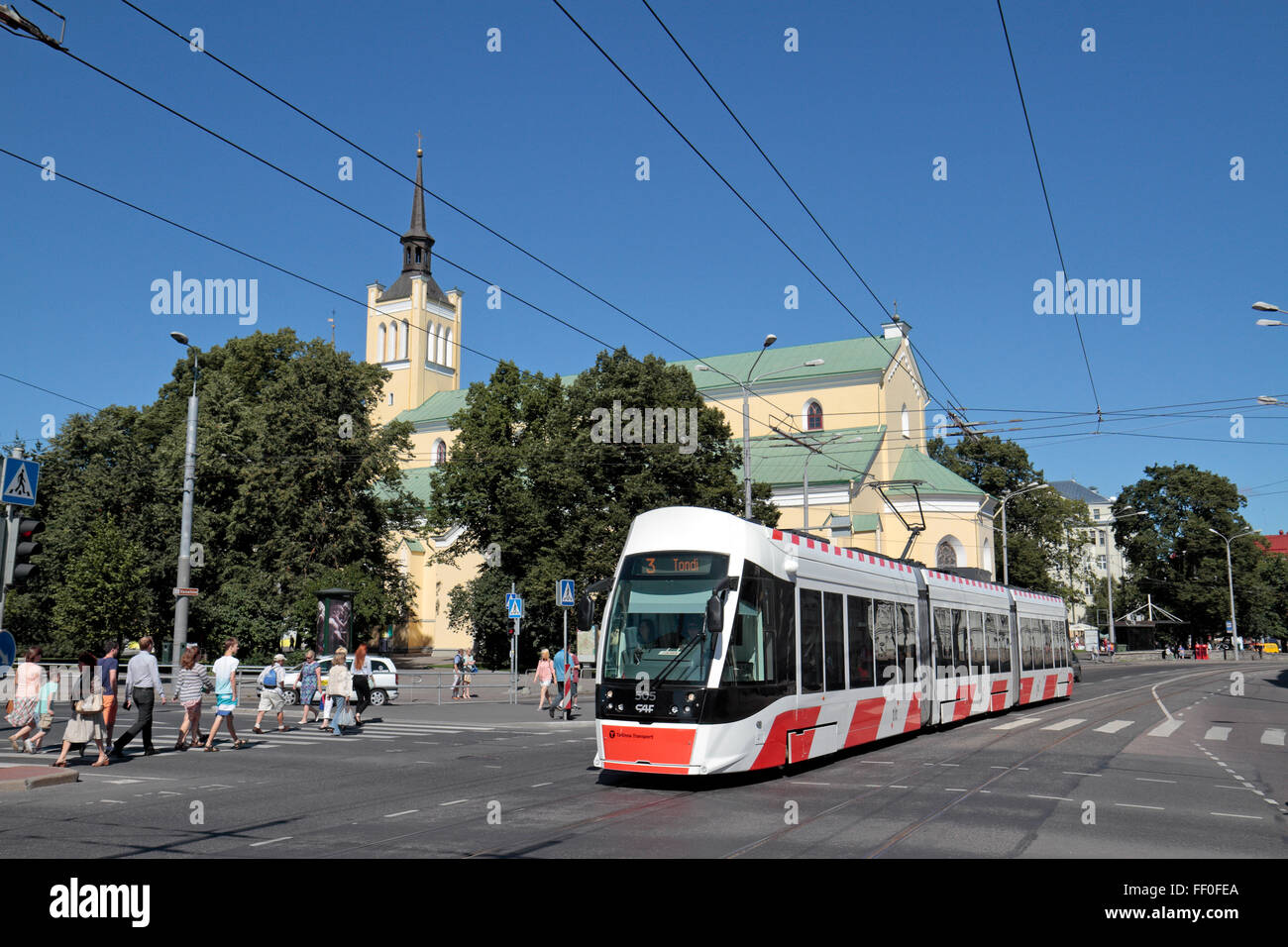 Un moderno tram elettrico passante chiesa di San Giovanni Evangelista, Tallinn, Estonia. Foto Stock