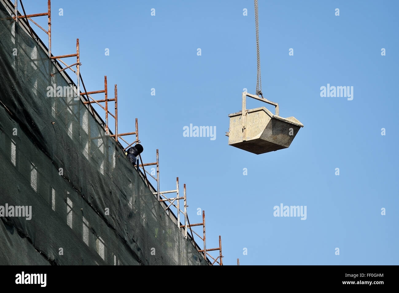 Irriconoscibile lavoratore edile guida di una gru da cantiere caricato con materiali Foto Stock