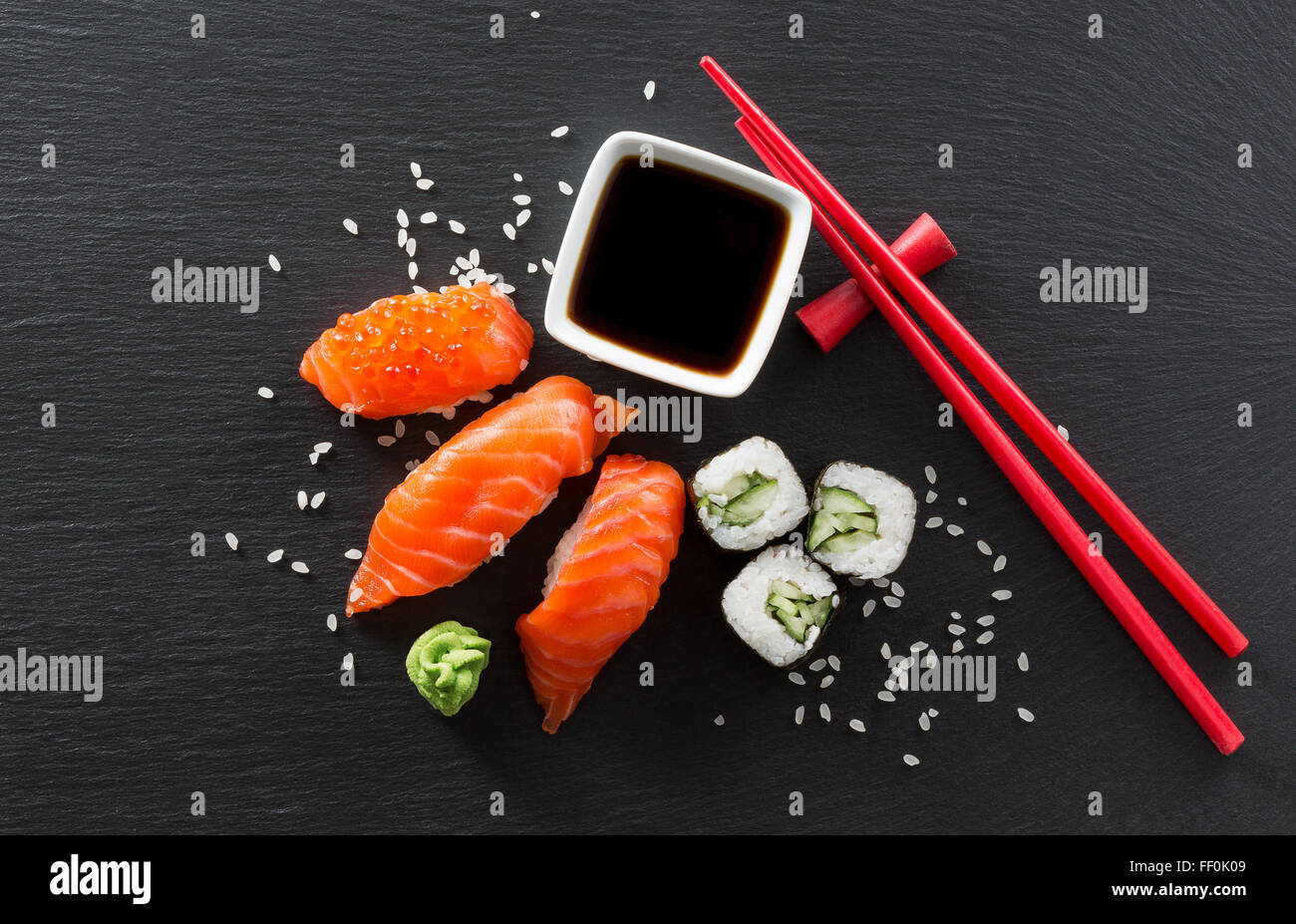 Il sushi e le bobine su una tavola di ardesia. Foto Stock