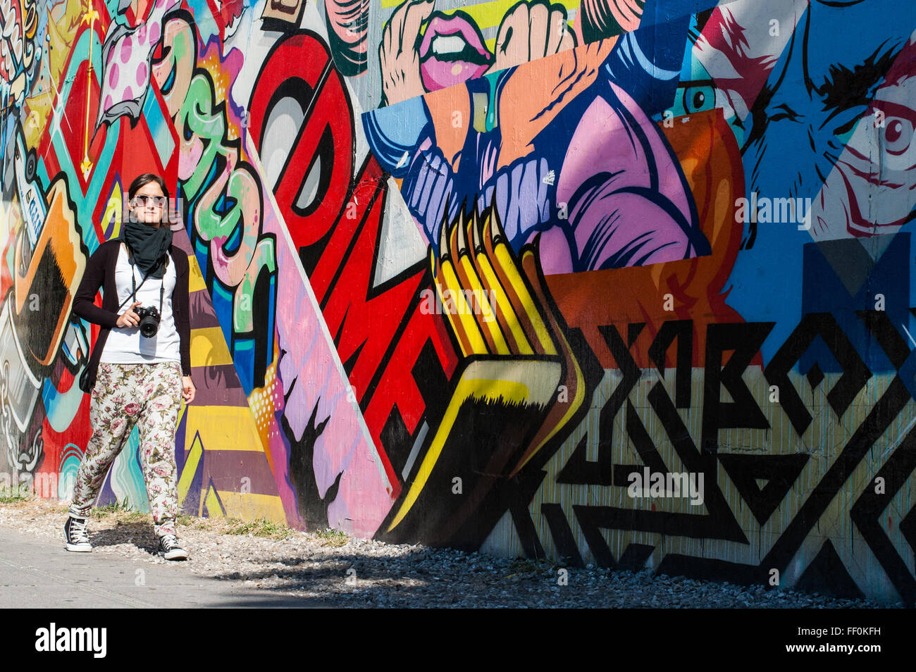 BROOKLYN, New York, US, 1 ottobre 2013: la street art di Brooklyn. Tanga fotografo femmina camminare al fianco di un muro di graffiti. Foto Stock