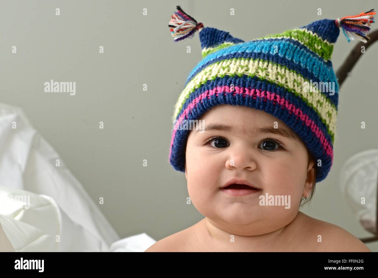 Dieci mesi di bambina indossa un cappello invernale Foto Stock