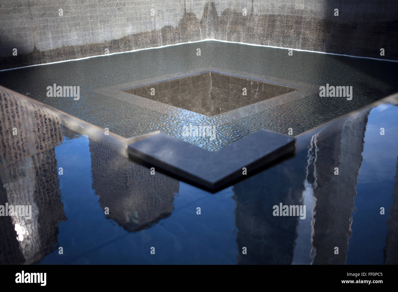 La riflessione di grattacieli decorare un squadrato monumento dedicato alle vittime del World Trade Center 911 attacchi in nuovo Foto Stock