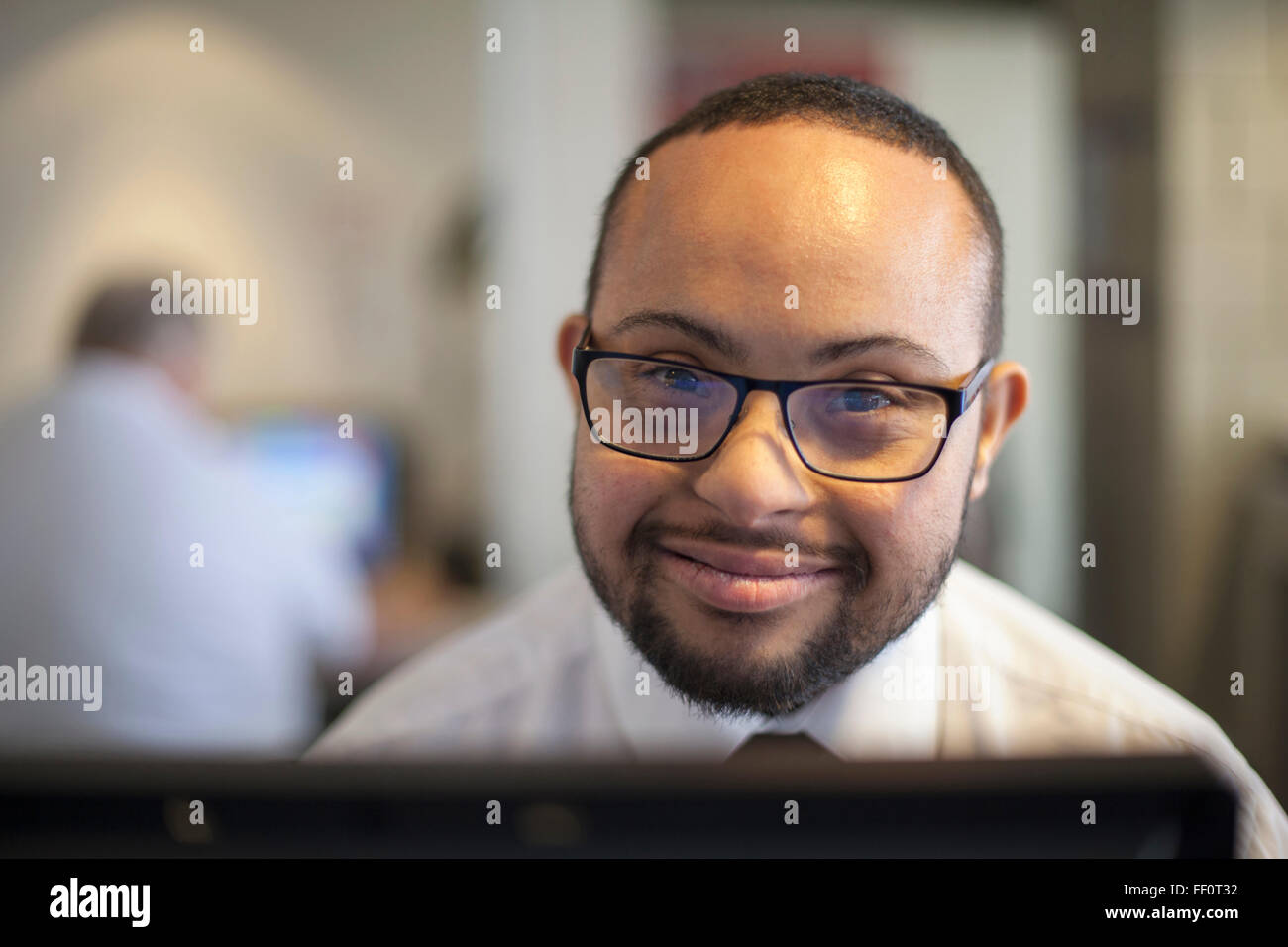 Razza mista imprenditore con la sindrome di down lavora sul computer Foto Stock