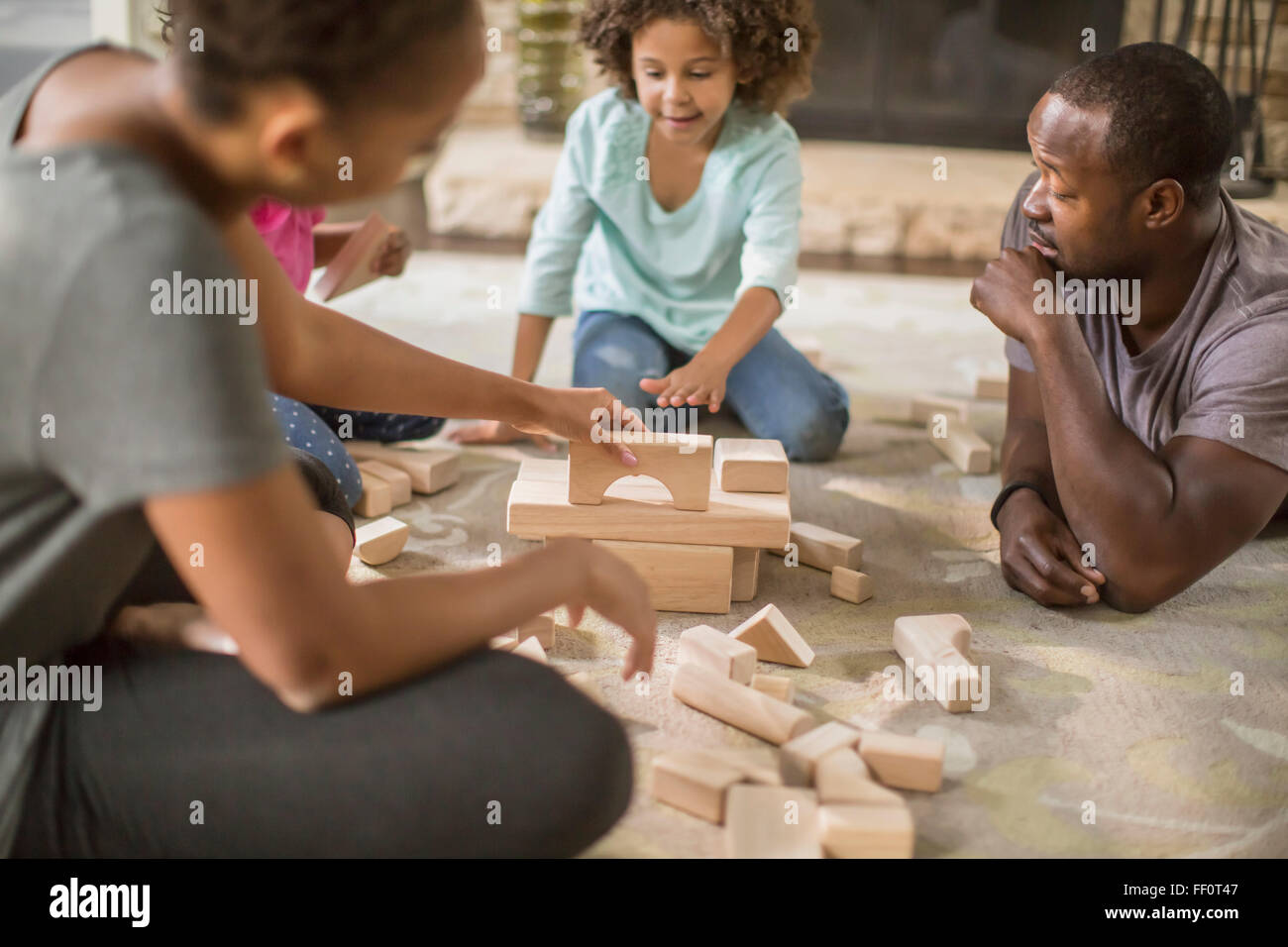 La famiglia gioca con la costruzione di blocchi in salotto Foto Stock