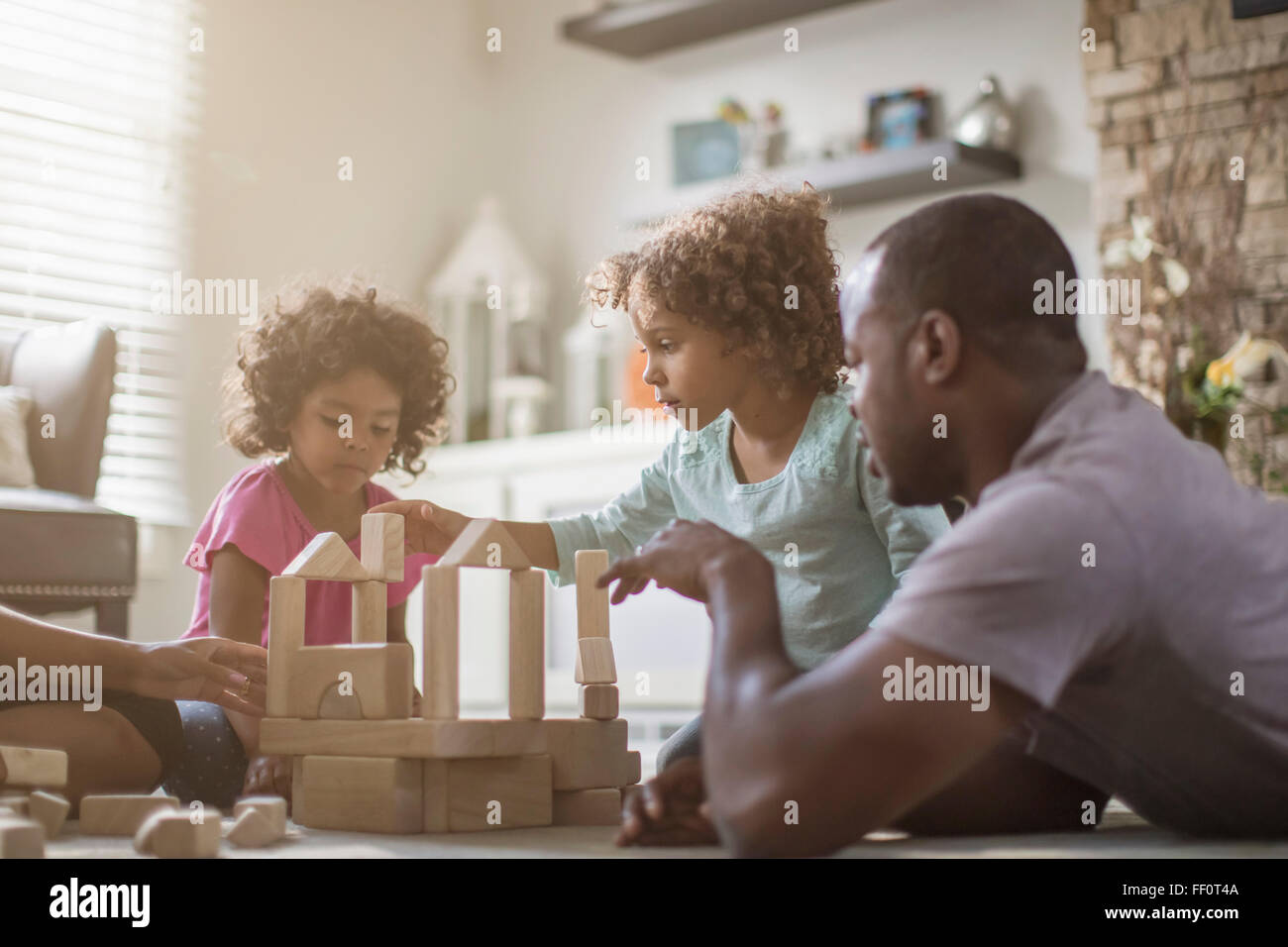 La famiglia gioca con la costruzione di blocchi in salotto Foto Stock