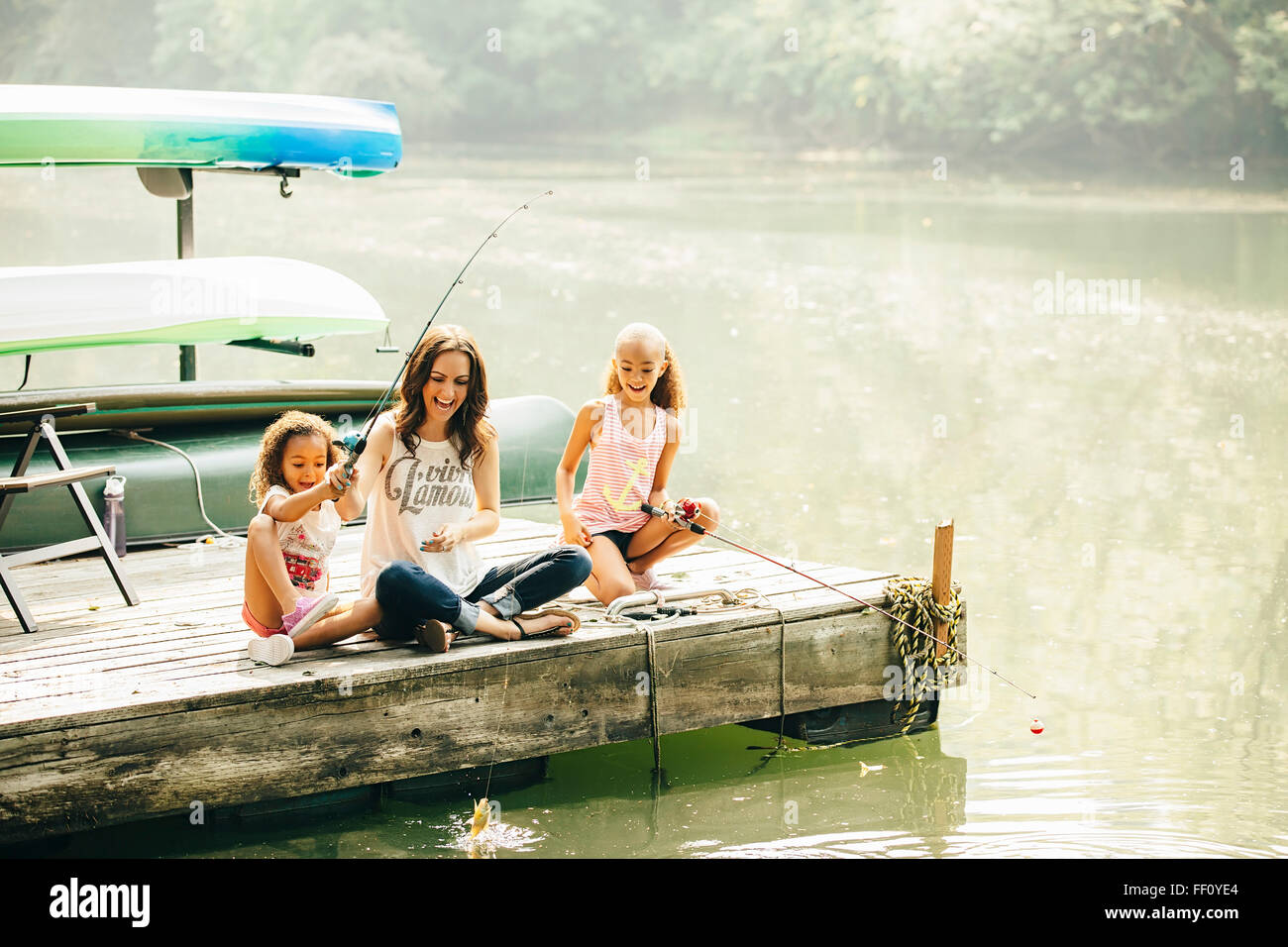 La madre e le figlie di pesca in lago Foto Stock