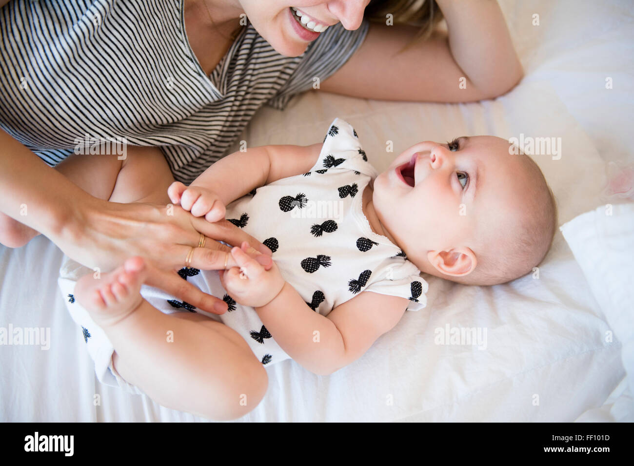 Caucasian il bambino e la madre figlia posa sul letto Foto Stock