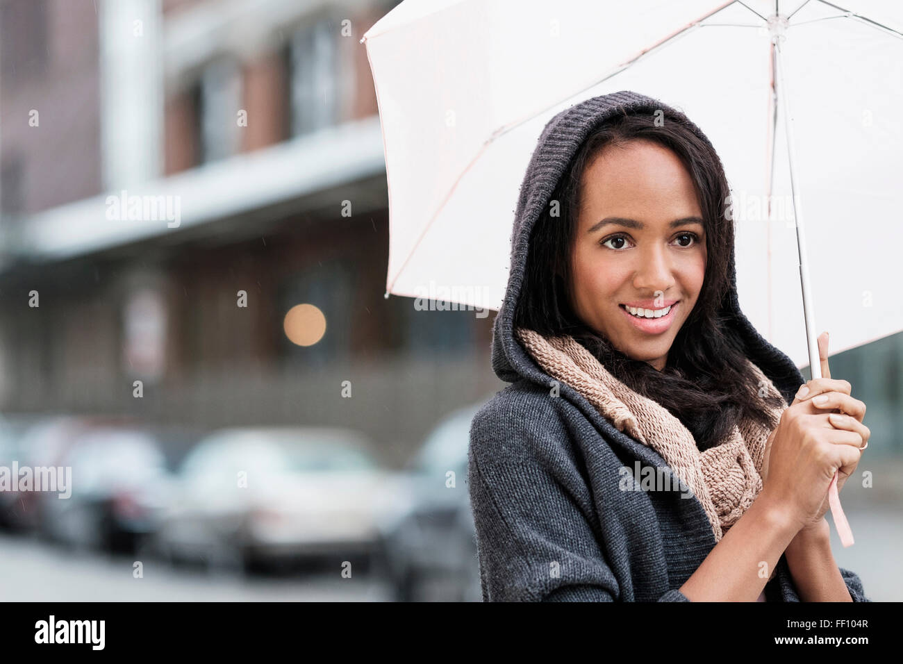 Razza mista donna ombrello porta all'aperto Foto Stock
