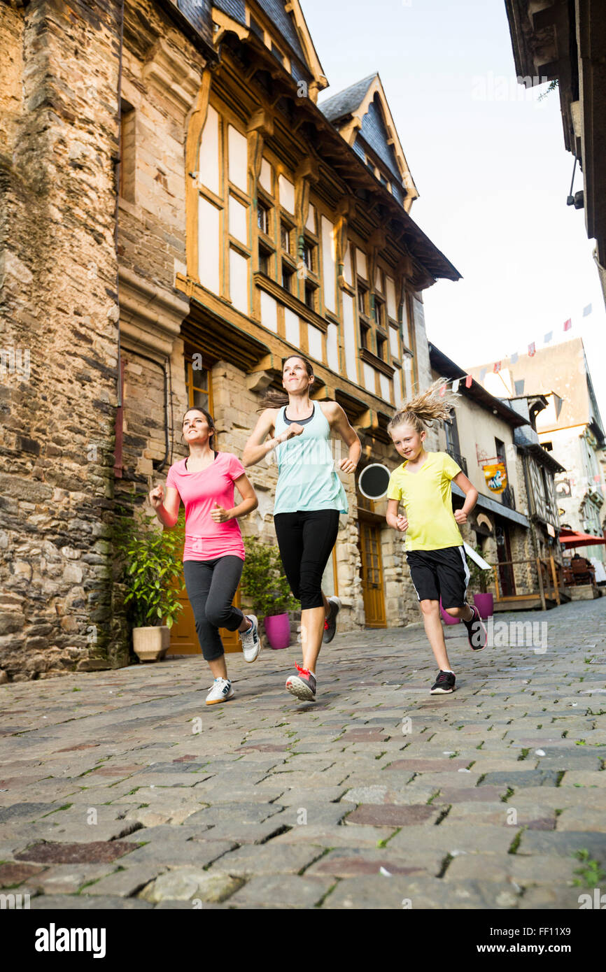 Donne caucasici jogging in villaggio Foto Stock