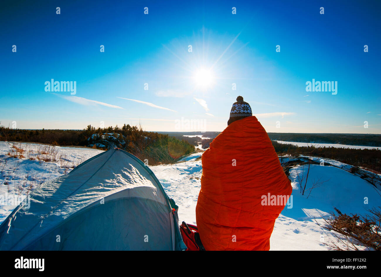 Escursionista permanente al campeggio nevoso Foto Stock
