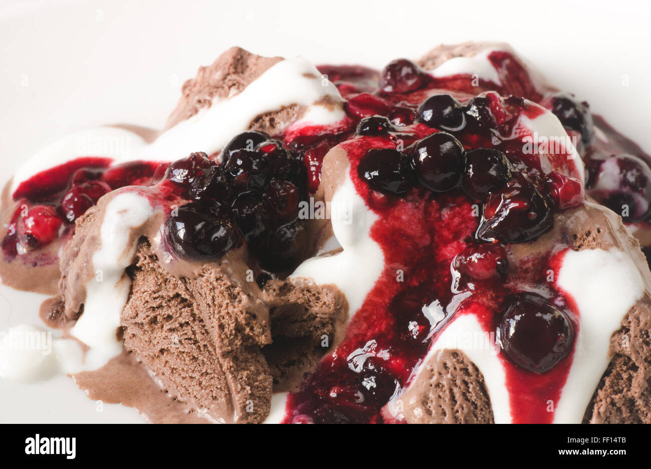 Gelato al cioccolato con panna montata e salsa di frutta Foto Stock