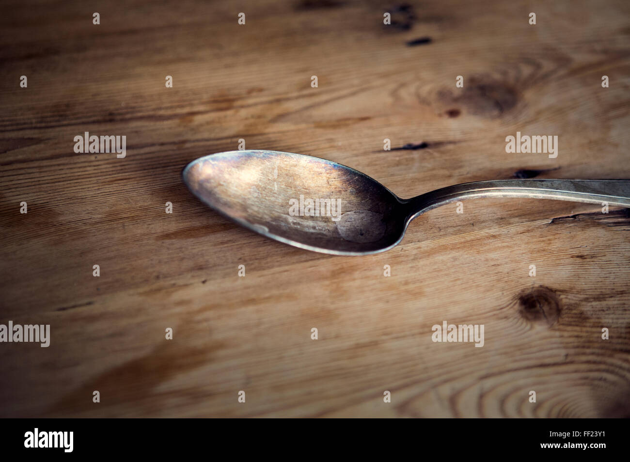 Vecchio cucchiaio d'argento sul tavolo di legno Foto Stock