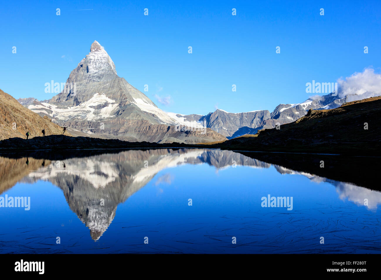 Gli escursionisti ammirando il Cervino riflesso nel lago Stellisee, Zermatt, Canton Vallese, Pennine, alpi svizzere, Svizzera Foto Stock