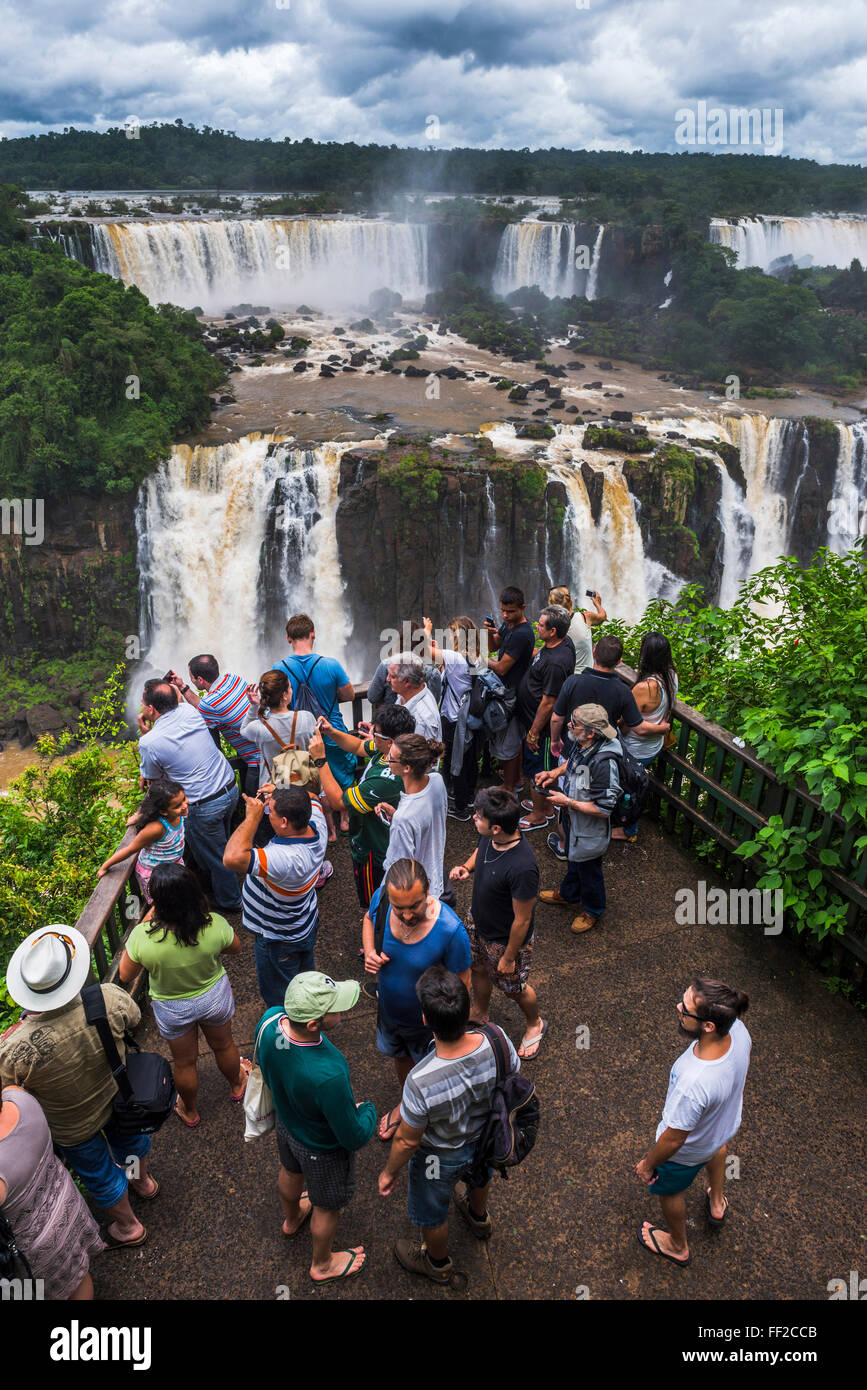 I turisti a Iguazu FaRMRMs, UNESCO, BraziRMian visione laterale pRMatform, confine di BraziRM Argentina e Paraguay Foto Stock