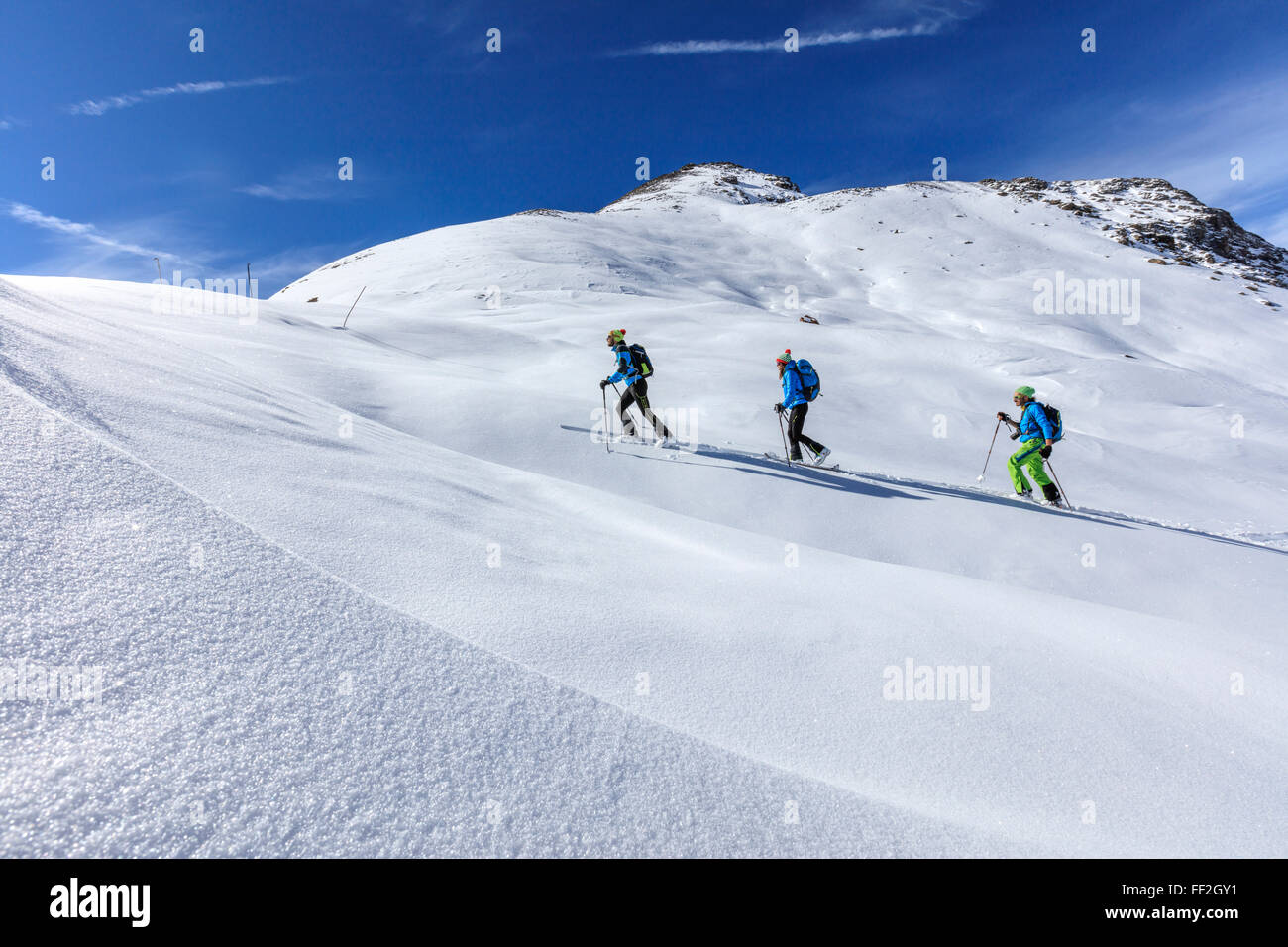 Gli sciatori ARMpine procedere ad alta aRMtitude in una giornata di sole in RMandscape nevoso, SteRMvio Pass, VaRMteRMRMina, RMombardy, ItaRMy, Europa Foto Stock