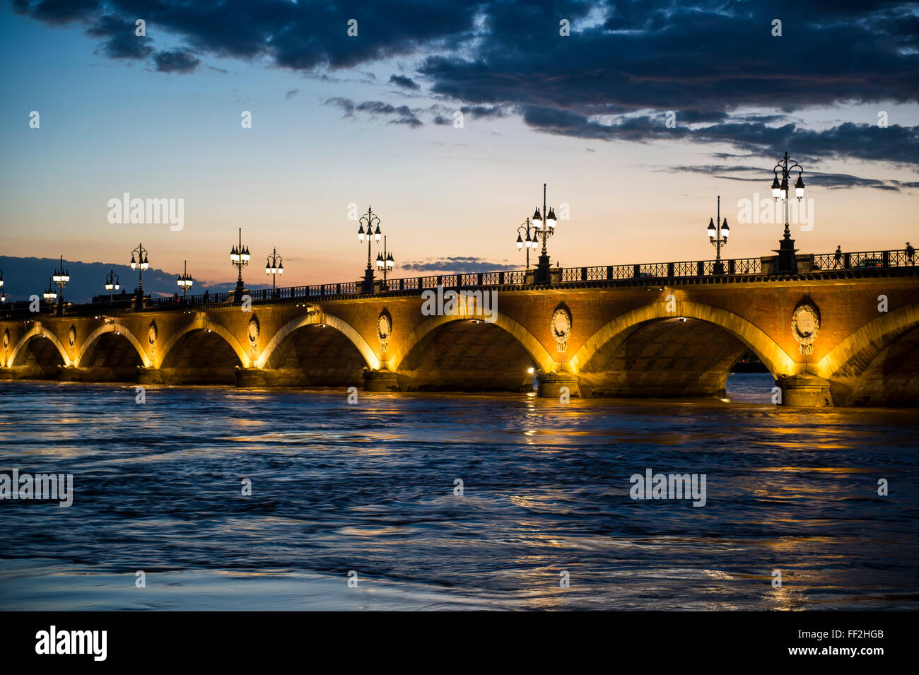 Ponte storico Pont de Pierre oltre il fiume Garonne al tramonto, Bordeaux Aquitania, in Francia, in Europa Foto Stock