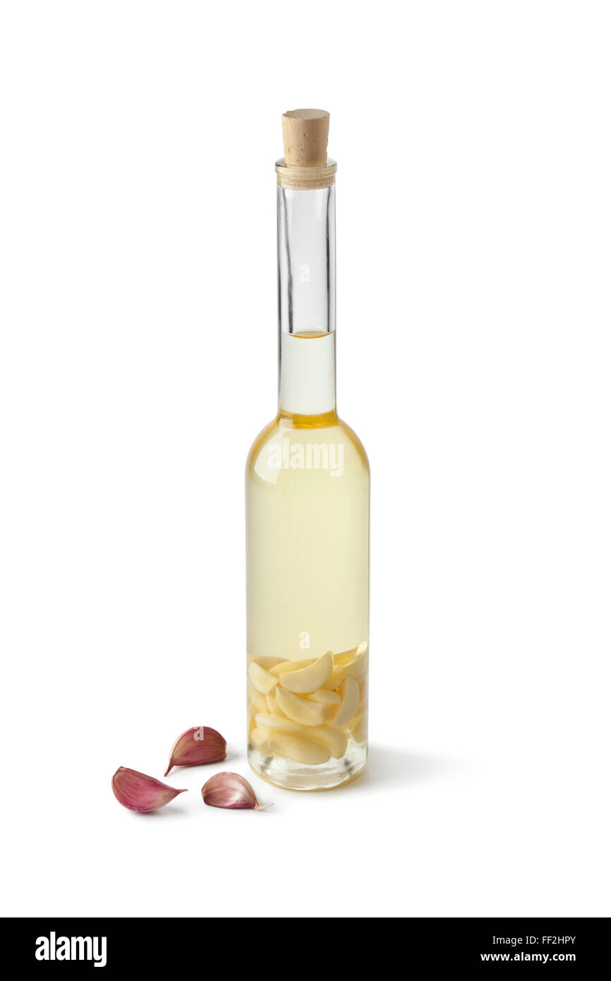 Bottiglia di olio di semi di girasole con aglio su sfondo bianco Foto Stock