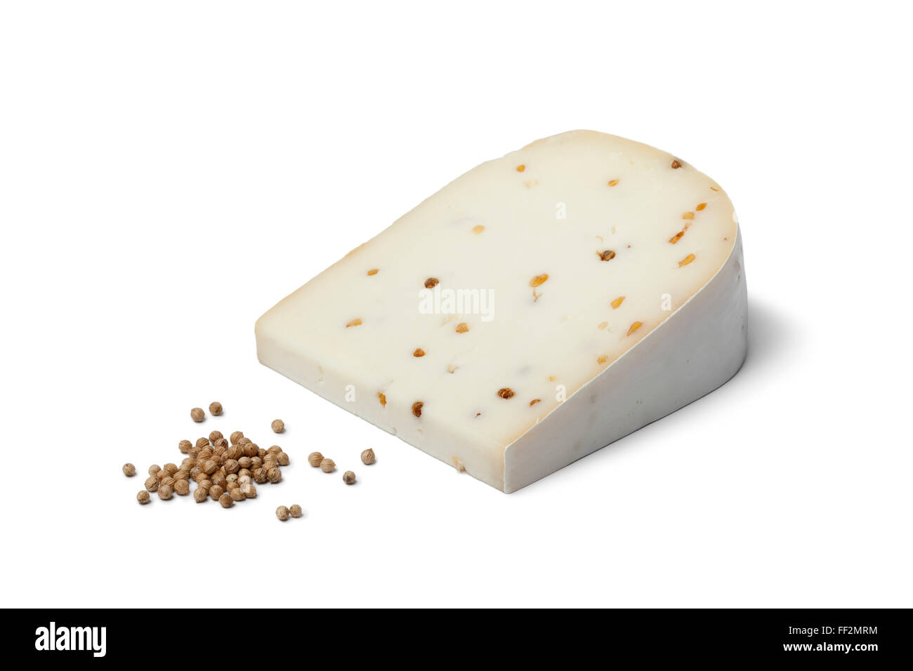 Pezzo di formaggio di capra con semi di coriandolo su sfondo bianco Foto Stock
