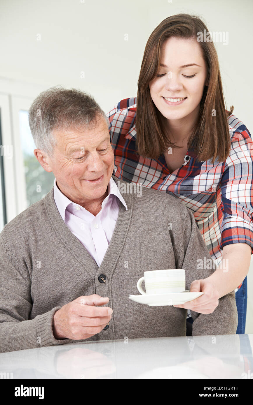 Teenage portando la NIPOTE nonno bevanda calda Foto Stock