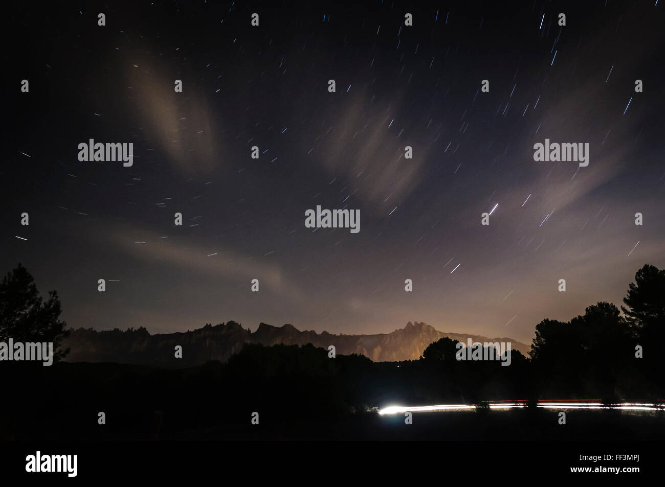 Lunga esposizione fotografia di Montserrat nella fredda notte invernale . Tracce stellari. Foto Stock