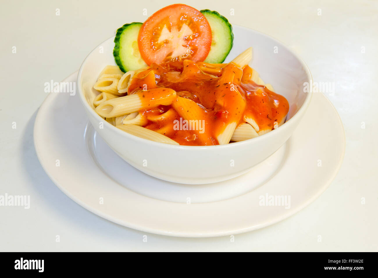 La salsa di pomodoro e la pasta in una ciotola con insalata di piccole dimensioni Foto Stock