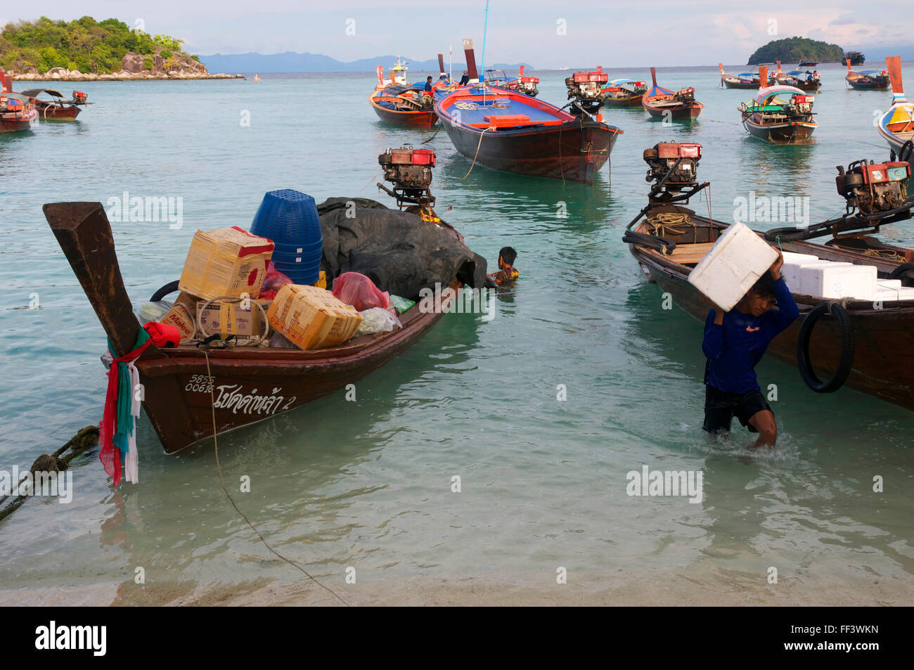 Longtail barche impilati con forniture consegnare circa costa di Koh Lipe. Foto Stock