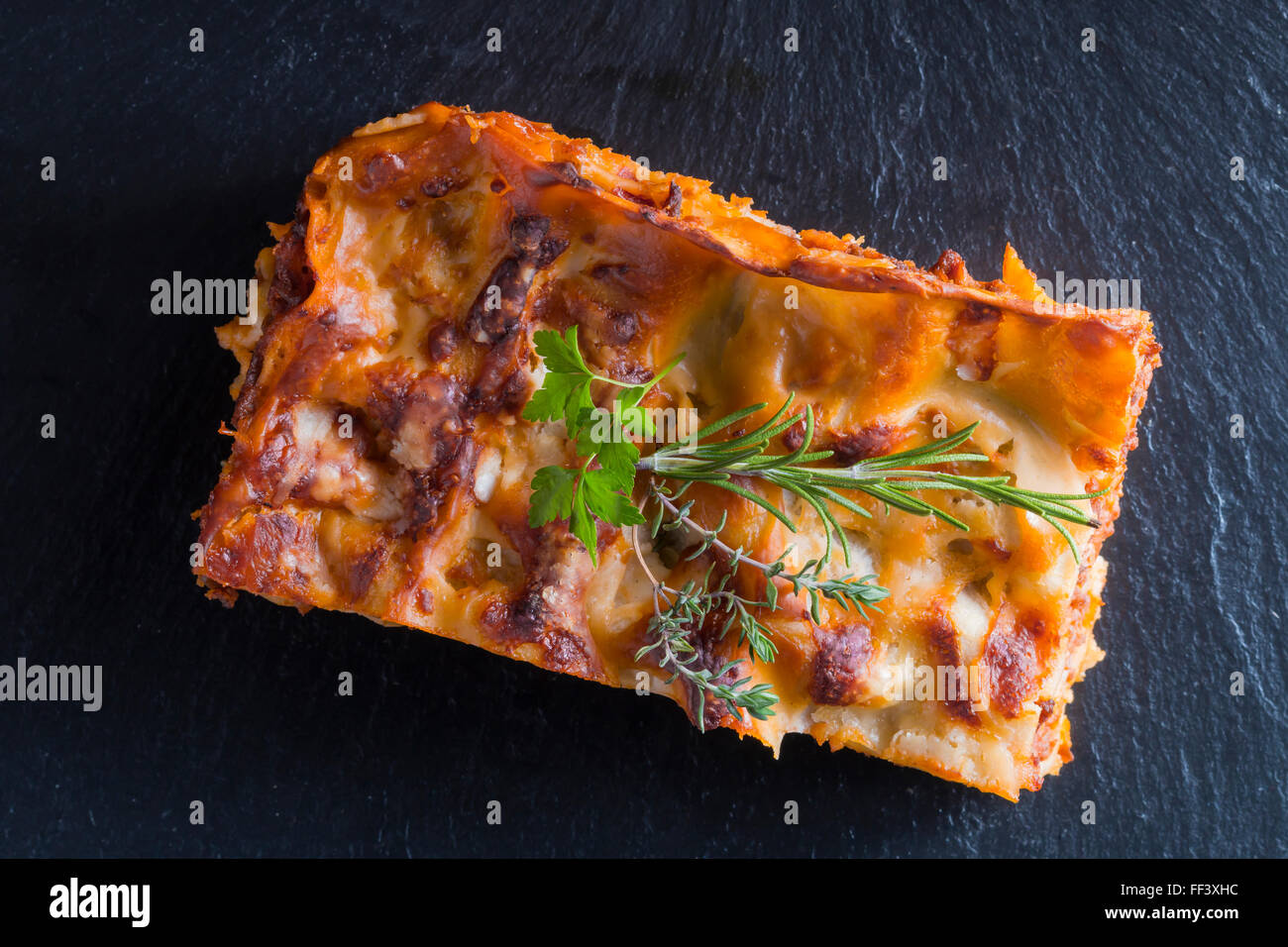 Cottura a vapore caldo lasagne con vino rosso su ardesia e tavolo in legno Foto Stock