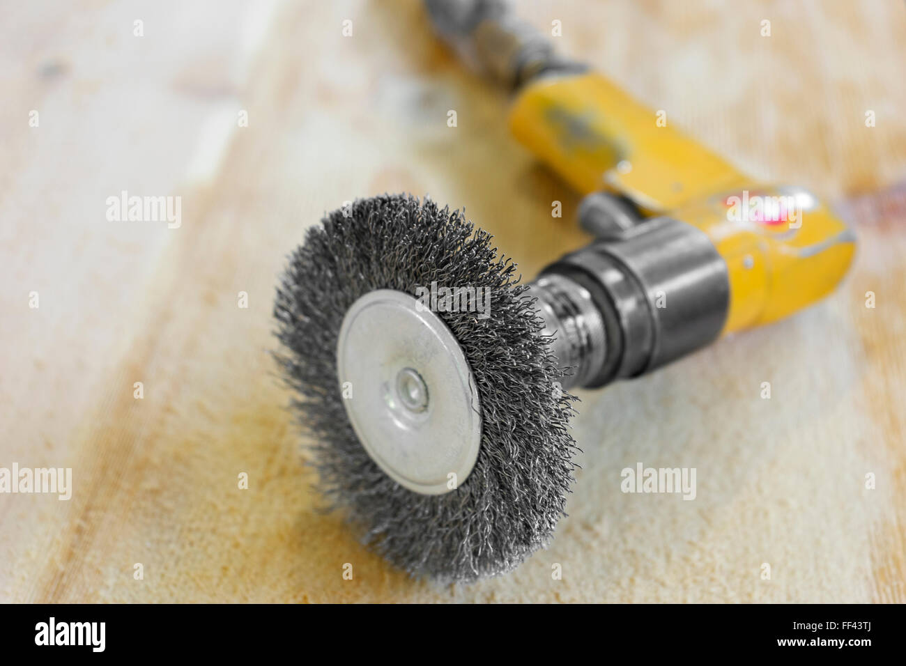 Elettrica spazzola rotante disco metallico levigazione di un pezzo di legno  Foto stock - Alamy