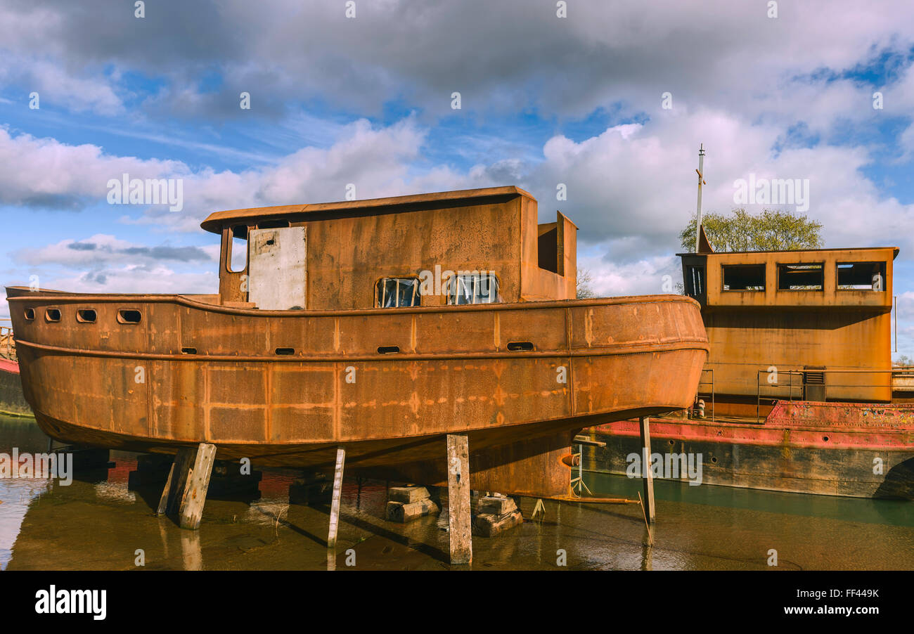 Abbandonata la ruggine barche di ferro che viene ripristinato sul fiume scafo su una luminosa giornata invernale a Beverley, nello Yorkshire, Regno Unito. Foto Stock