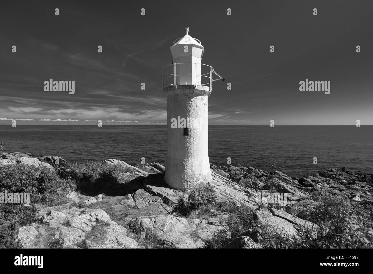 Faro bianco,blu del mare e del cielo in condizioni di luce solare intensa a Stenshuvud National Park a Costa del Mar Baltico in Skane, Svezia Foto Stock