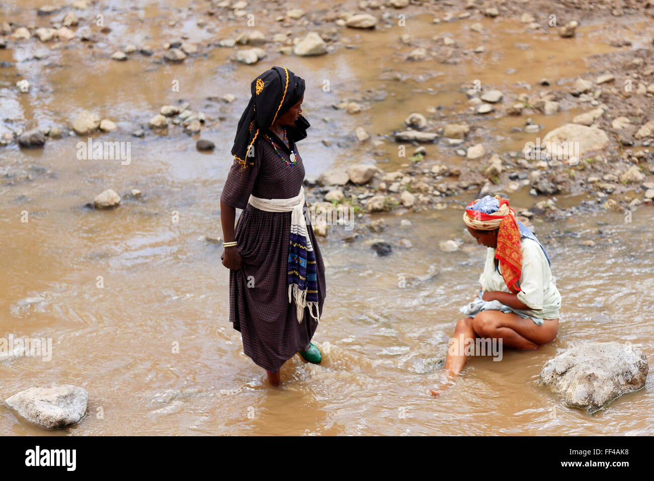 SENBETE, ETIOPIA-marzo 24, 2013: Le donne-oromo chat persone e organi di lavaggio in acqua di fiume che scorre attraverso il mercato. Foto Stock