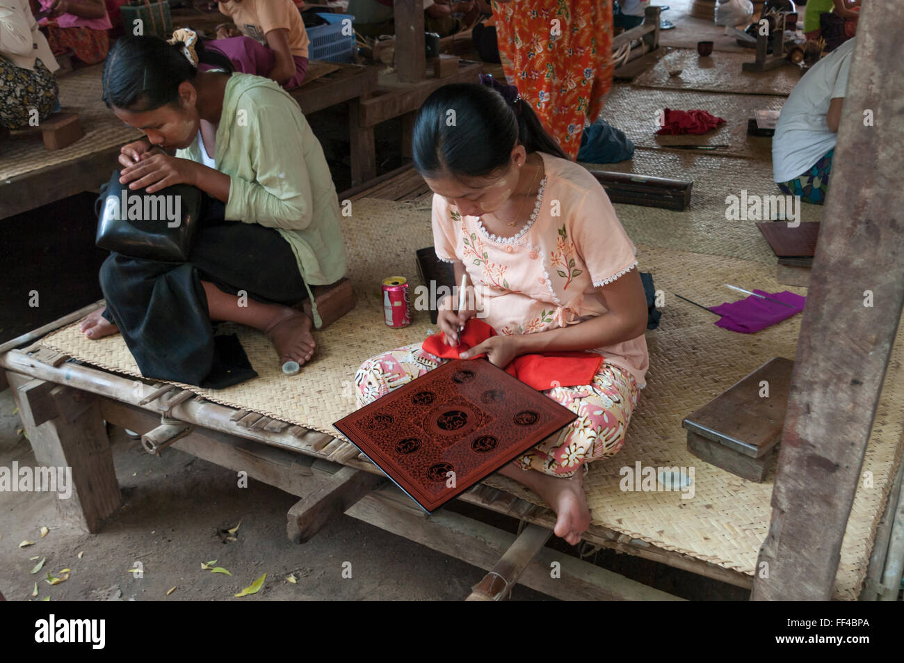 Donne birmane schemi di attacco ad una laquerware sito di fabbricazione. Nyaung-U, Bagan area, Myanmar (Birmania). Foto Stock