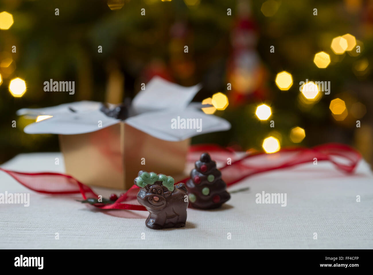 Novità di Natale fatti a mano i cioccolatini, compresa una renna contro lo sfondo di albero di Natale luci. Foto Stock