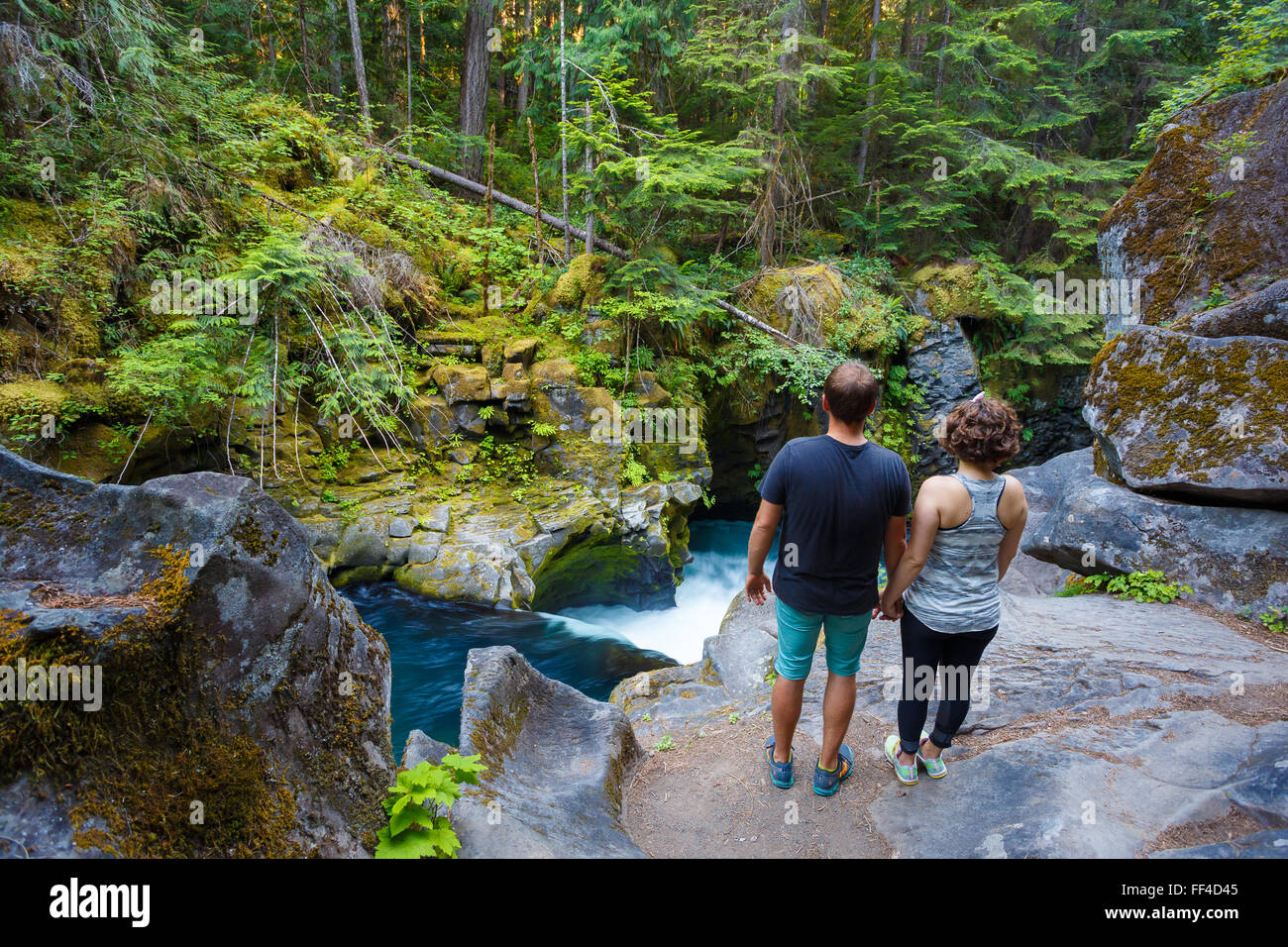 L uomo e la donna ad esplorare il nord Umpqua fiume sopra Toketee Falls in Oregon. Foto Stock