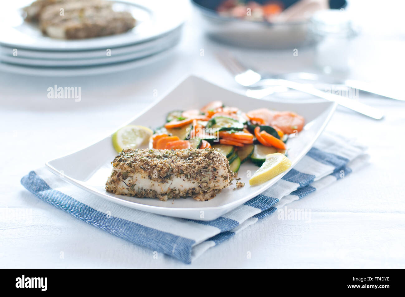 Merluzzo bianco con il piccante panatura servita con carote e zucchine Foto Stock