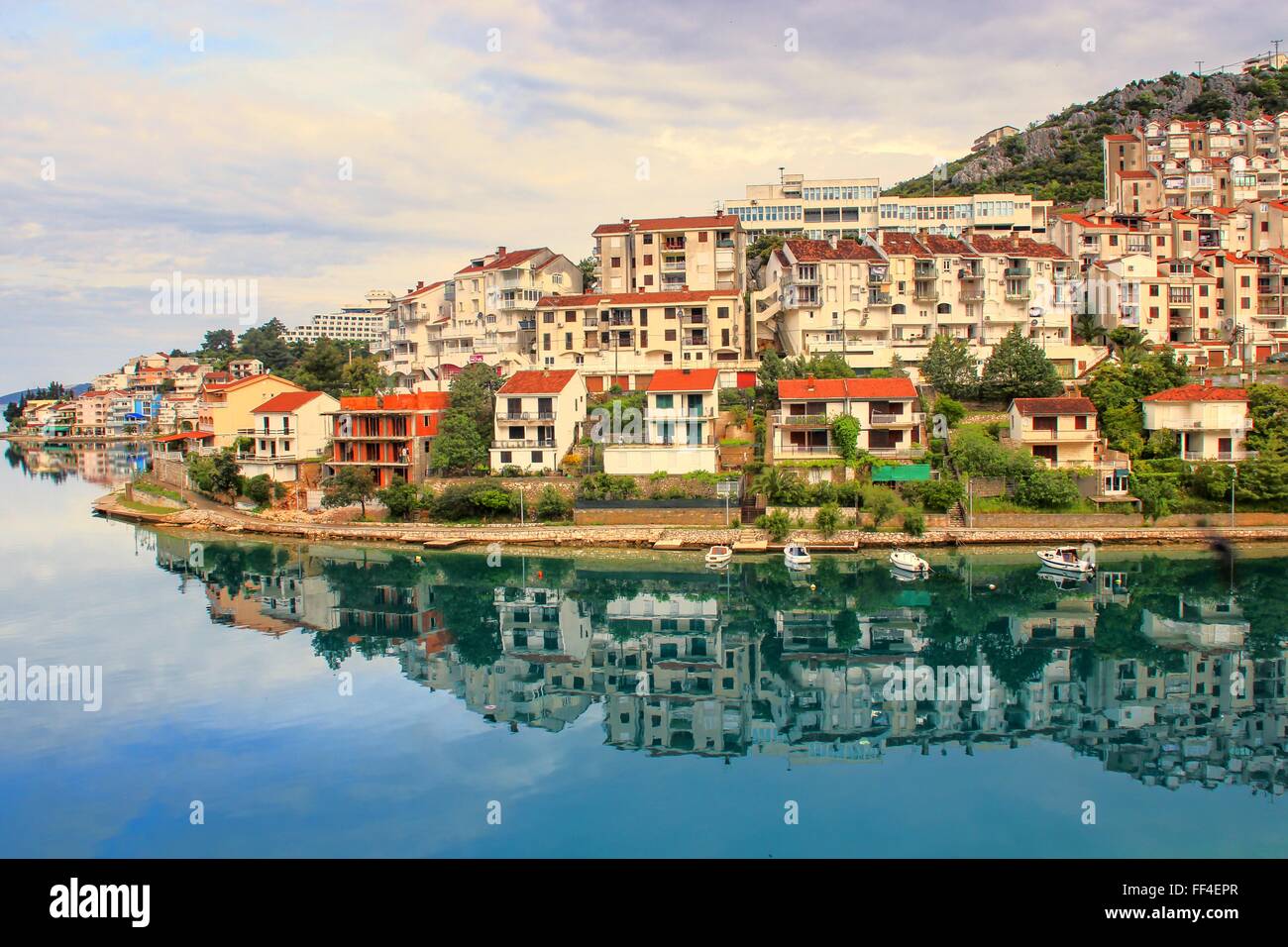 La bella riflessione di un piccolo villaggio in europa nel silenzio della baia di mattina. Neum in Bosnia Erzegovina. In silenzio l'acqua. Foto Stock