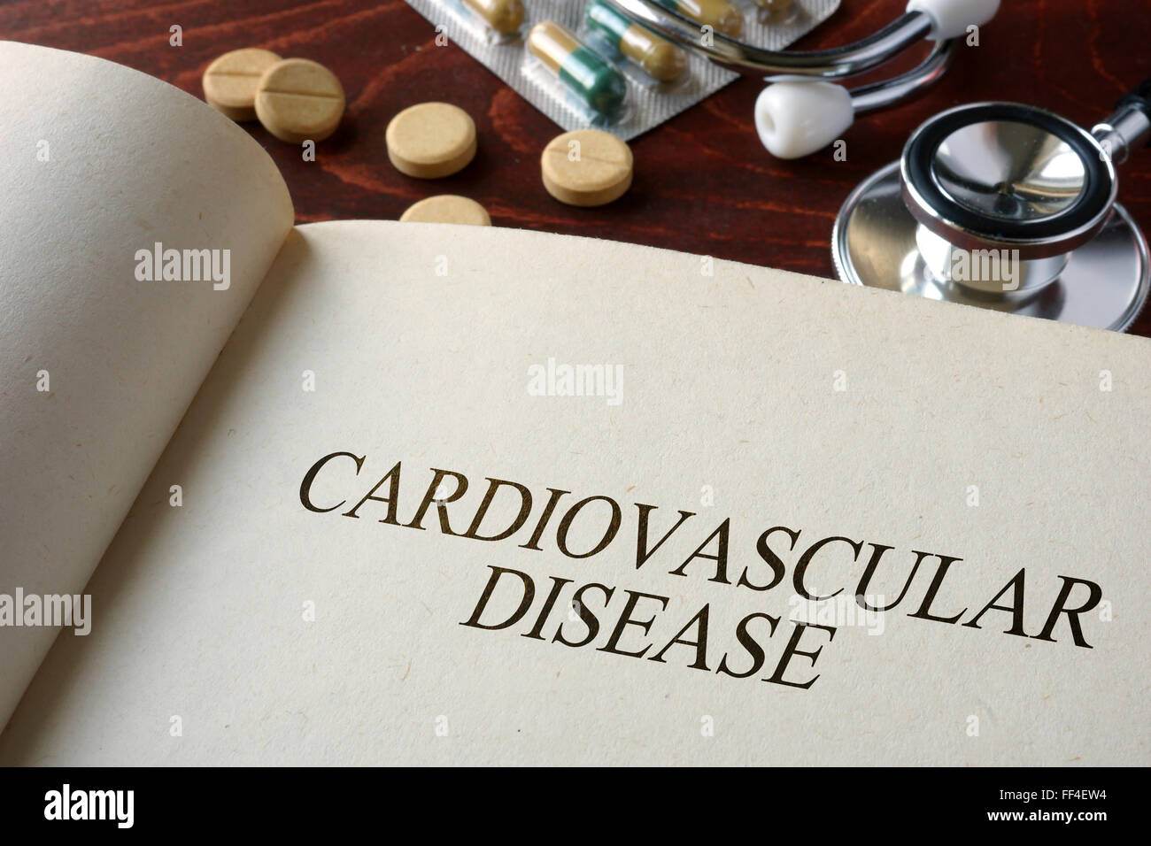 Prenota con diagnosi di malattie cardiovascolari e pillole. Concetto medico. Foto Stock
