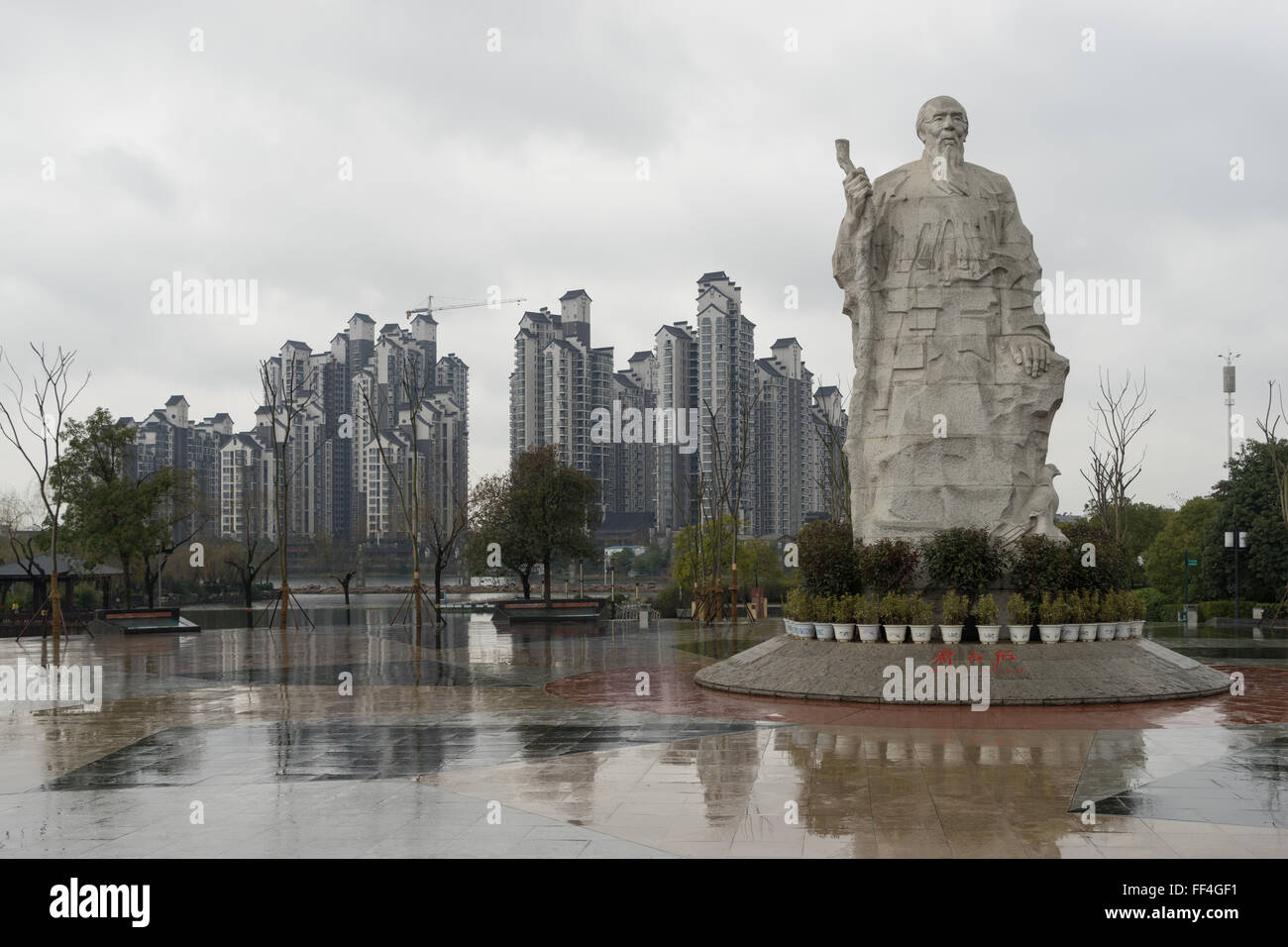 Pittore Qi Baishi statua in un parco a Xiangtan Hunan, Cina, con edifici residenziali in background Foto Stock