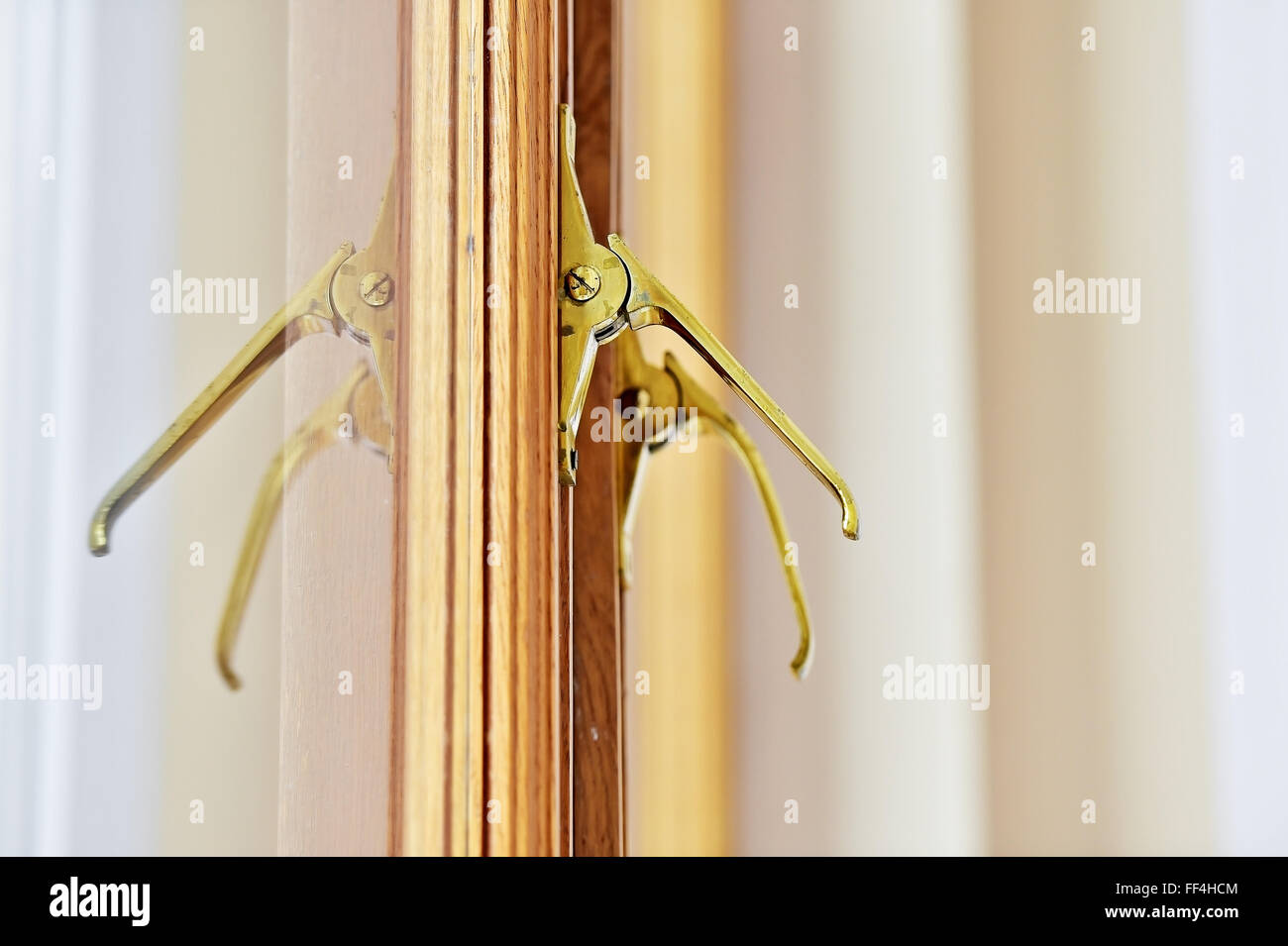 Dettaglio shot con vintage golden handle della finestra su una tavola di legno sul telaio di una finestra Foto Stock