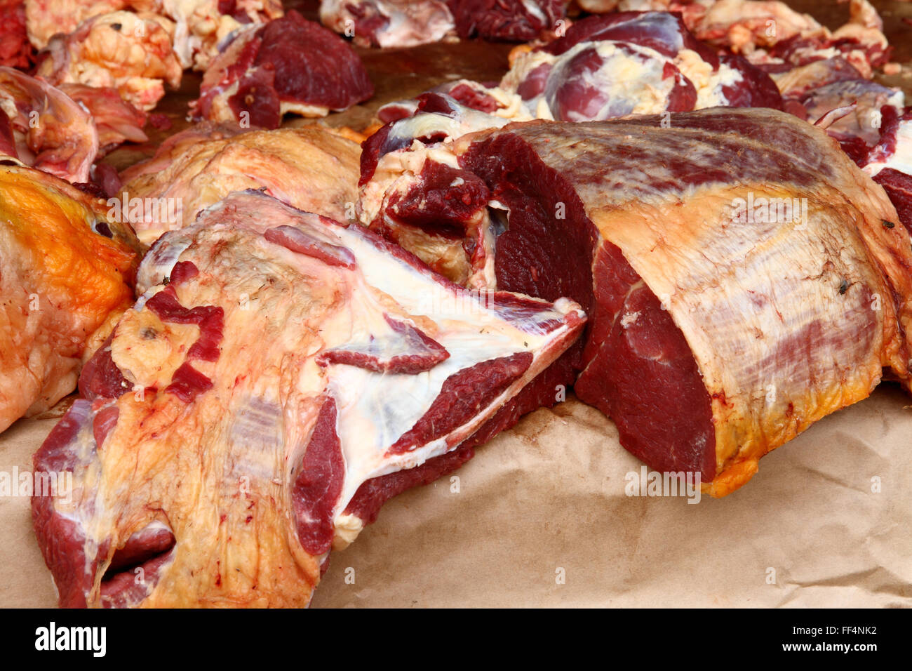 Grandi pezzi di carne cruda, manzo, sedersi su un caldo aria aperta contatore in un mercato a Kampala in Uganda. Foto Stock