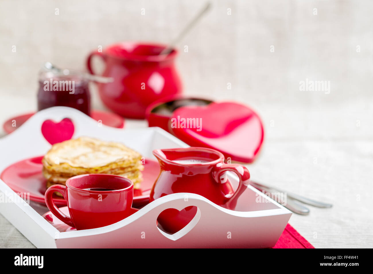 La prima colazione. Frittelle e caffè con latte in un vassoio per il giorno di San Valentino. Messa a fuoco selettiva. Foto Stock