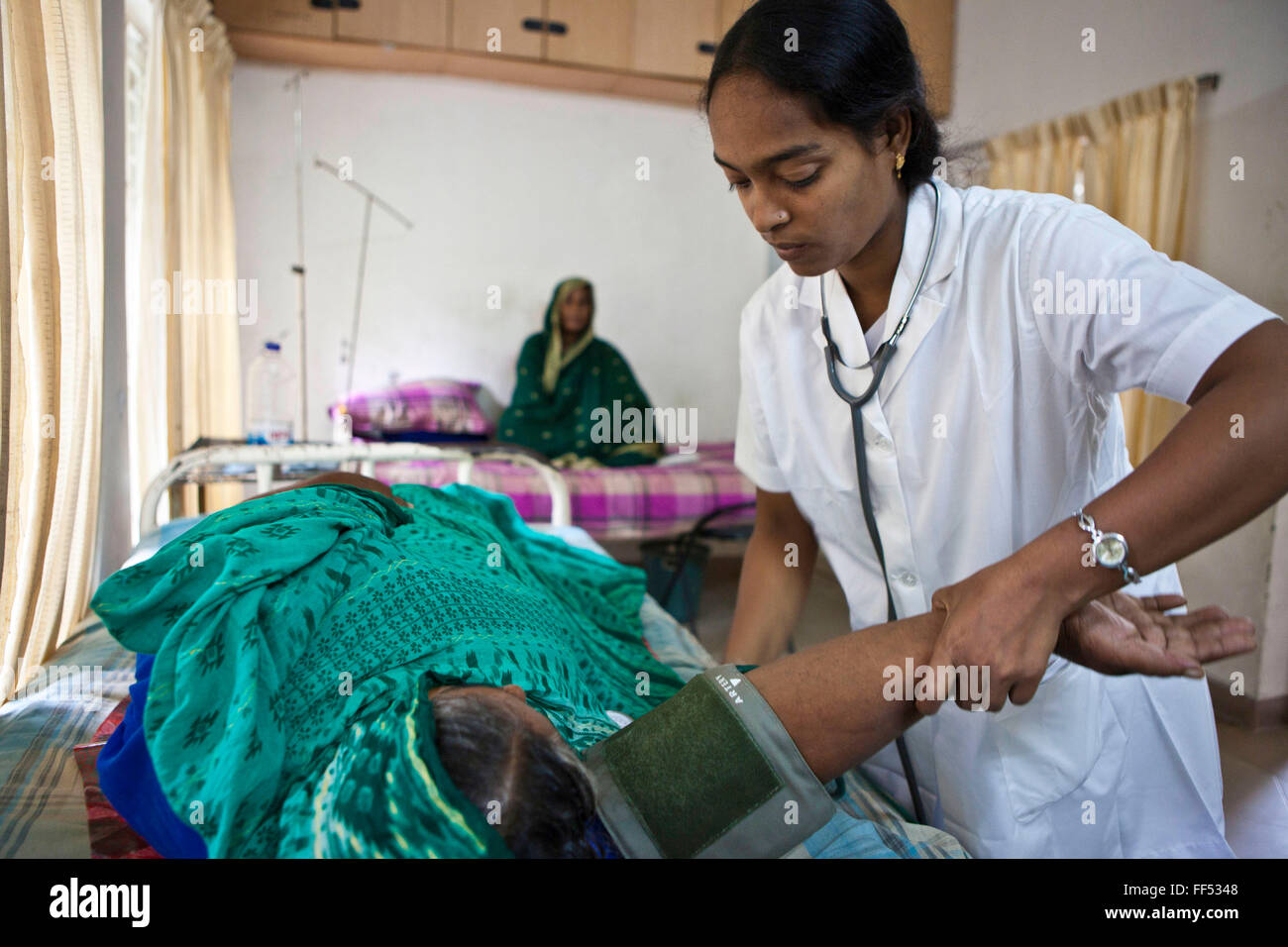 Un medico donna compie un esame su una signora anziana a IFB Chuandanga ospedale nella regione occidentale del Bangladesh. Impatto Foundation Bangladesh (IFB) fornire assistenza, supporto e trattamento per le persone con disabilità in Bangladesh. Ci sono circa 13 milioni di persone che vivono con una disabilità in Bangladesh e IFB lavoro per prevenire la disabilità evitabili attraverso semplici interventi utilizzando le conoscenze esistenti e tecnologia. Foto Stock