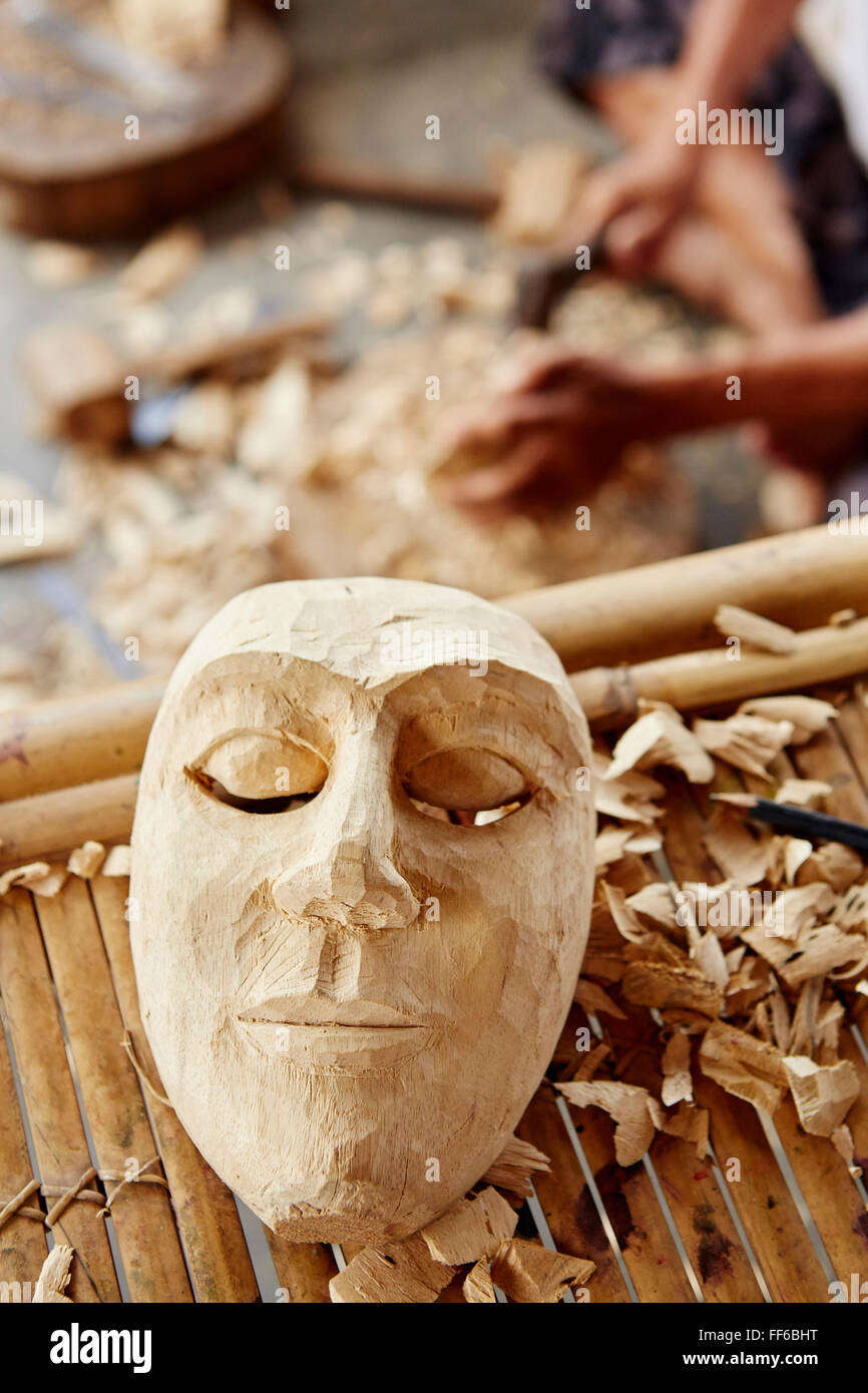Un tradizionale maschera di legno essendo realizzati in un carver della bottega. Foto Stock