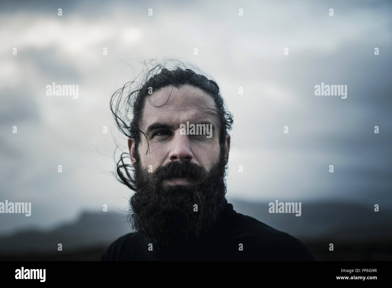 Un uomo con i capelli neri un pieno di barba e baffi. Foto Stock