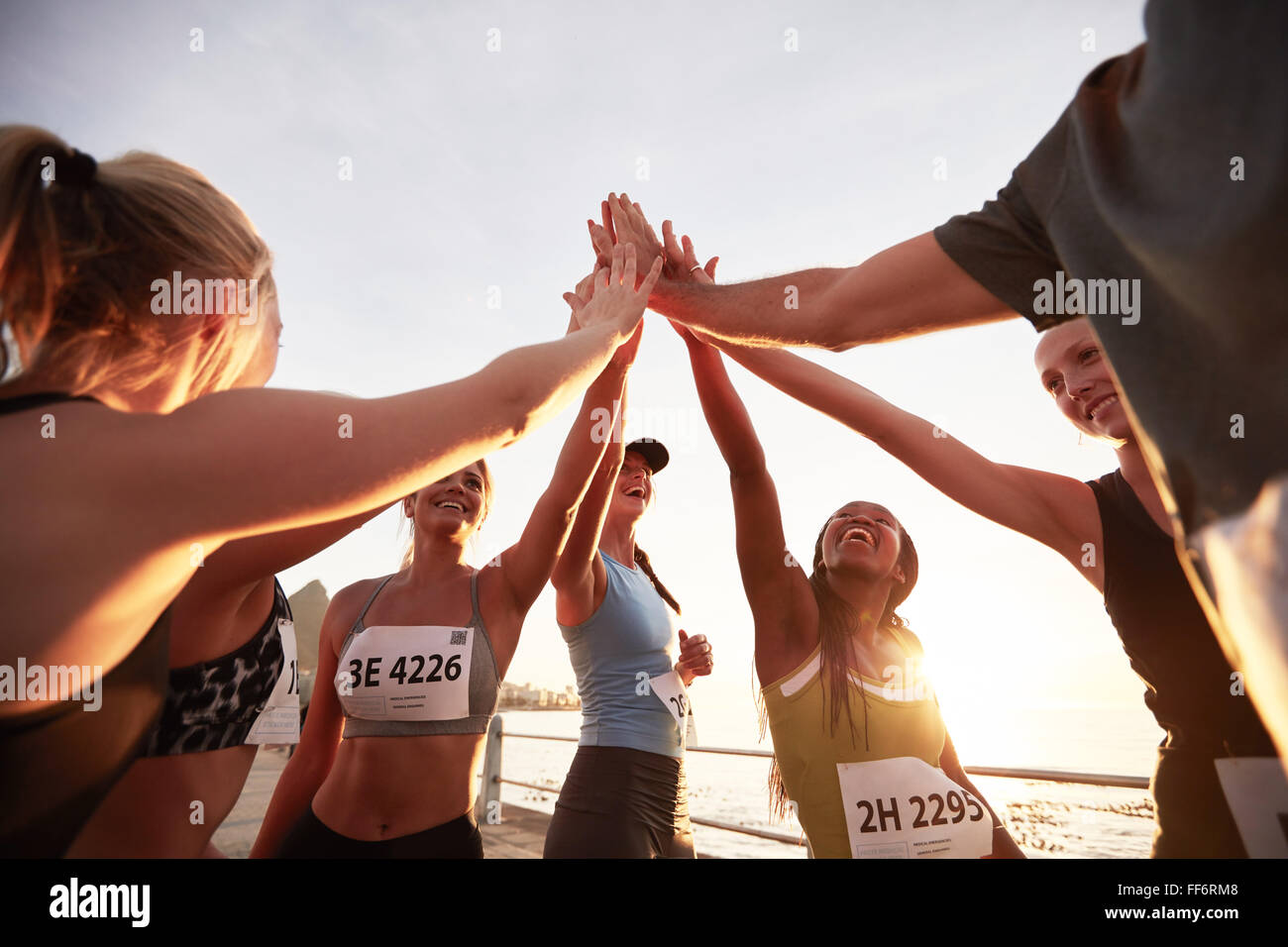 Guide di scorrimento ad alta fiving ogni altro dopo una buona sessione di formazione. Gruppo di atleti di dare ad ogni altra alta cinque dopo la gara. Foto Stock