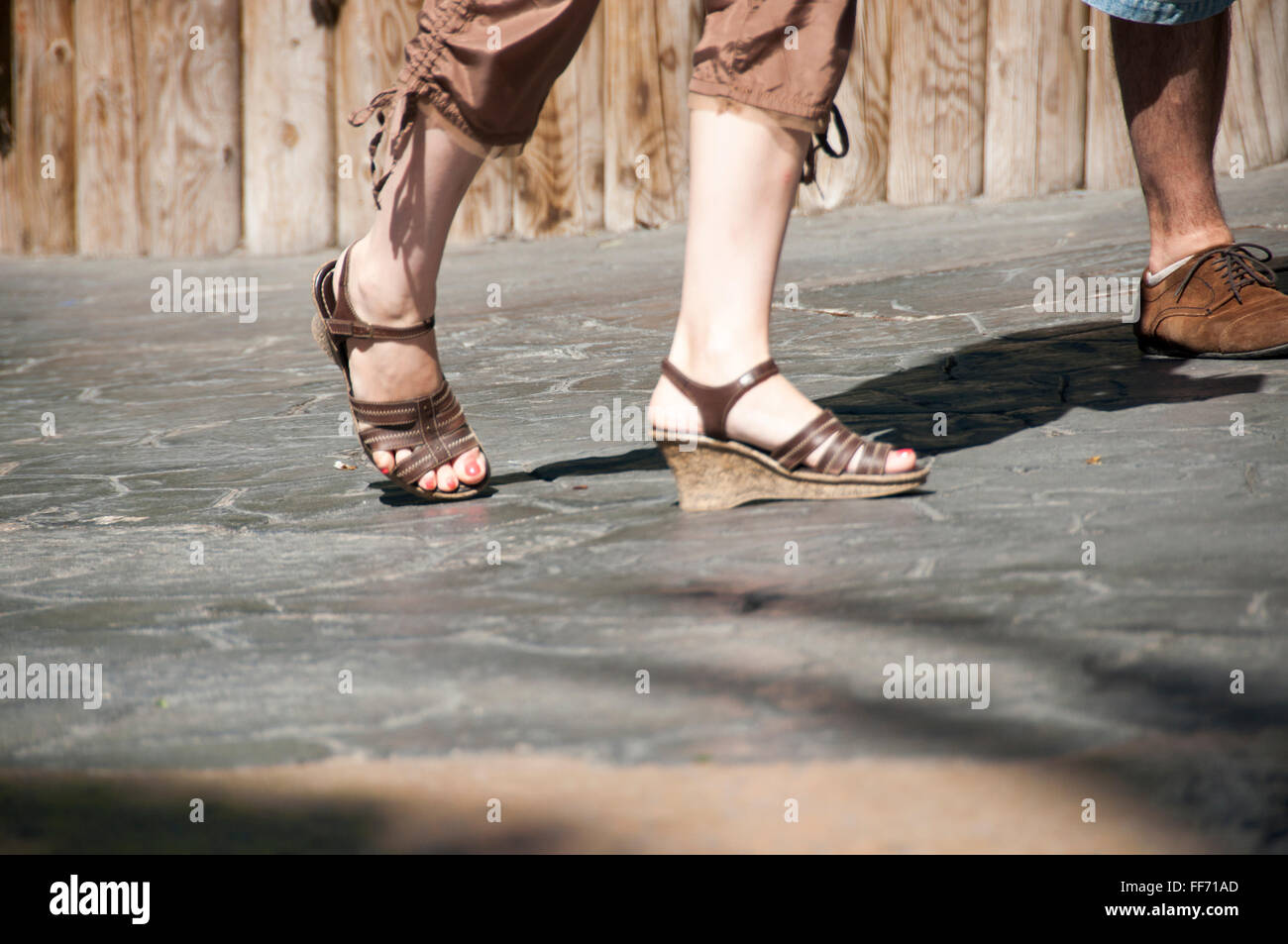 Gambe e marrone donna di sandali. Foto Stock