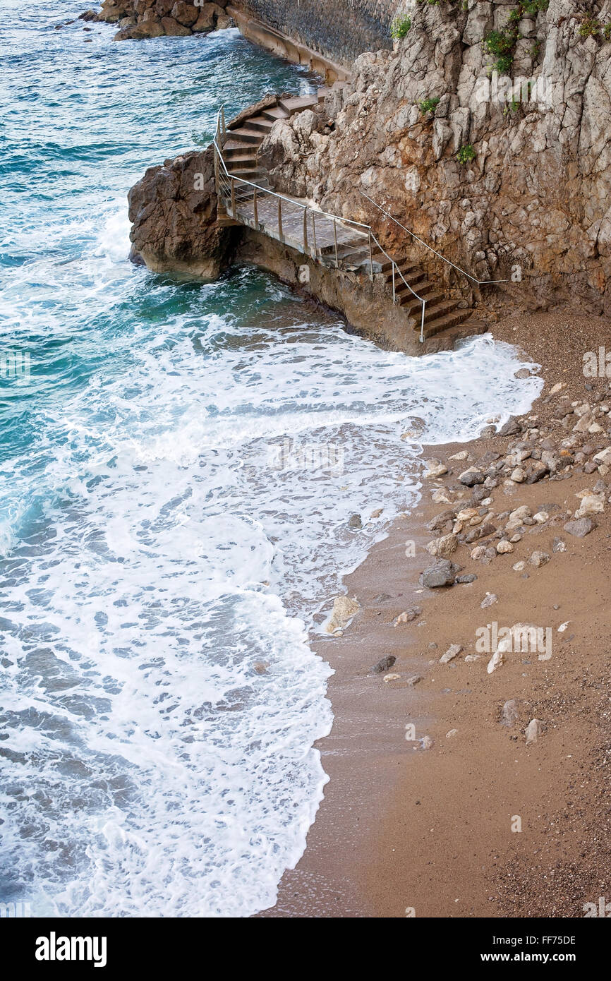 Scala a un po' di spiaggia intorno a una ripida parete di roccia, collegando le due spiagge del Mar Mediterraneo, Monte Carlo, Monaco Foto Stock