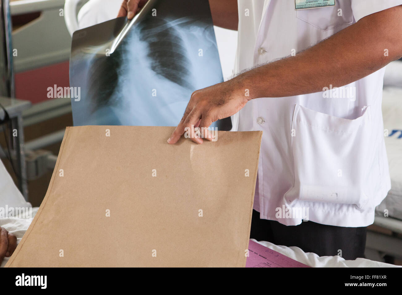 Un medico di mettere una X-ray torna nella sua busta. Foto Stock